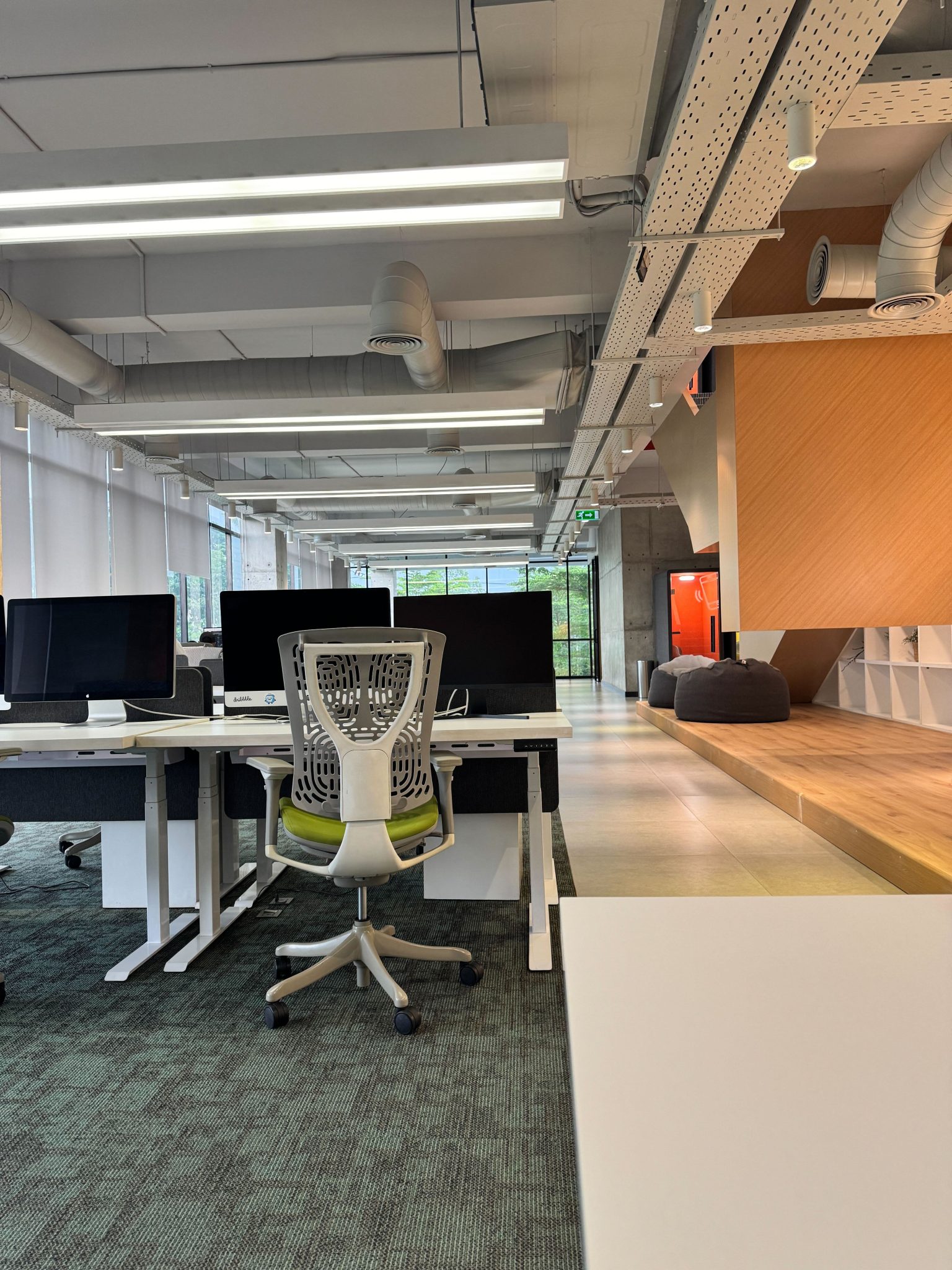 Modernes Büro mit Schreibtischen, Monitoren und ergonomischen Bürostühlen